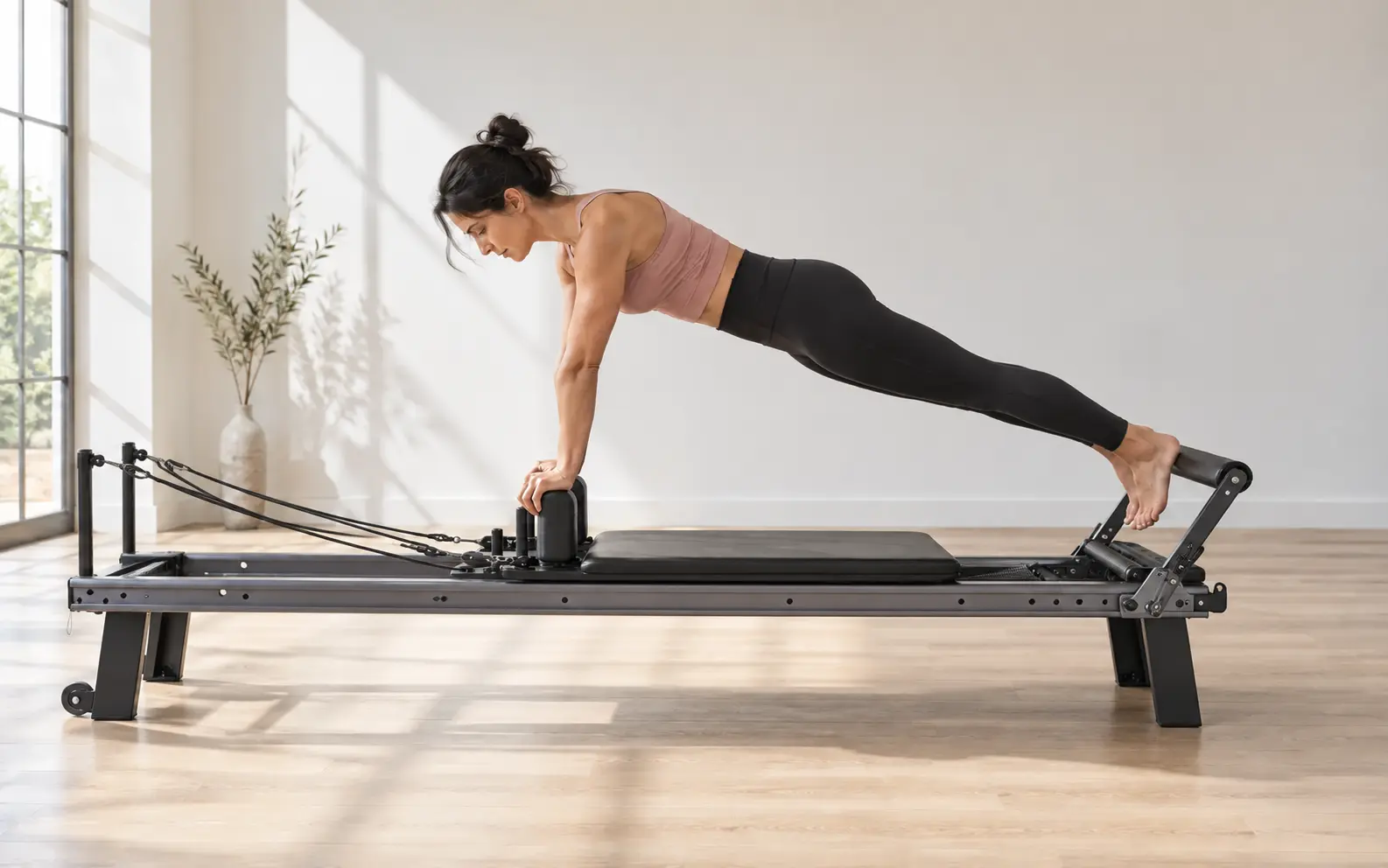 Frau trainiert kontrolliert und kraftvoll auf einem Pilates Reformer